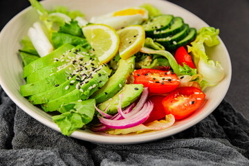 Avocado salad egg, tomato, onion, green leaf salad vegetable dish natural tasty snack fresh gourmet food background on the table rustic top view copy space keto and paleo diet vegan and vegan food