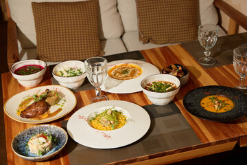 A Variety of Assorted Gourmet Dishes Displayed on a Beautiful Wooden Table Setting for Dining