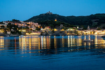 Naklejka premium Night view on sea bay, lights and colourful houses of Collioure, Cote Vermeille, Pyrenees-Orientales, Occitania, France. Summer vacation destination