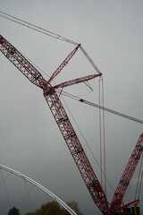 Massive Red Industrial Crane Operating Near The Waterside Bridge In Trent Basin, Nottingham, Under An Overcast Sky, Showcasing Heavy Construction Equipment.