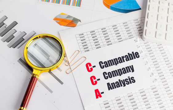 Comparable company analysis acronym written on paper with financial charts, magnifying glass and calculator