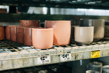 Display of colorful ceramic pots for sale in a home goods store during daytime