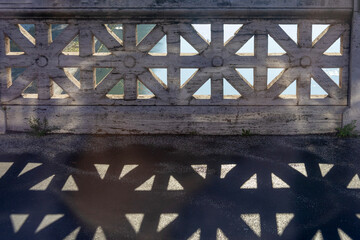 Geometry created by a balustrade against the sun and its shadow on the street, Rome, Italy