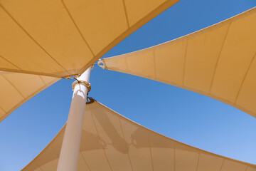 The yellow canopy is photographed against a blue sky background
