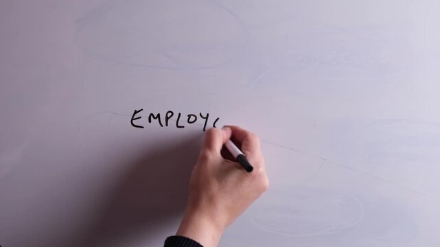 An HR business professional is writing Employee Engagement on a whiteboard in black marker pen, ideal for HR, recruitment, and business workplace presentations.
