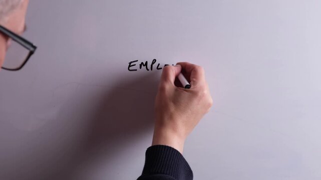 An HR business professional is writing Employee Experience on a whiteboard in black marker pen, ideal for HR, recruitment, and business workplace presentations.