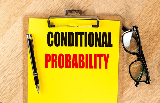 Conditional probability text written on yellow clipboard with black pen and eyeglasses on wooden table