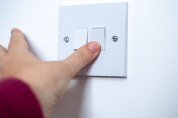 Fingers flipping switch, demonstrating electrical safety, electrical safety, home appliance control, power switch, circuit breaker