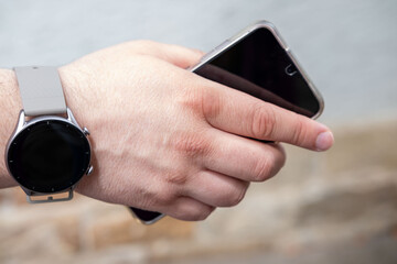 Hand holding smartphone, Personal smartwatch connecting to digital world, Wearable tech for modern life and connectivity, Time, notifications, and health tracking, active lifestyle