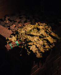 Oak broom for sauna lying on brick stove