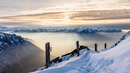 Winter Sunset Over Snowy Mountains and Sun Rays Through Mist. Rochers-de-Naye, Vaud, Switzerland.
