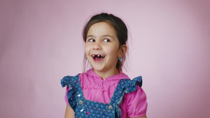 Adorable little girl smiling, laughing, and making funny faces against a pink studio background, showing a wide range of positive emotions from happiness and joy to surprise and amusement