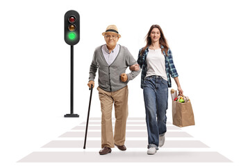 Young female carrying a grocery bag and walking with a senior man at zebra crossing