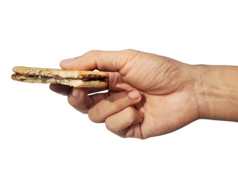 Holding a chocolate filled cracker in hand, isolated on PNG background.