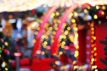 Christmas lights and fir branches on the street are out of focus. Christmas texture for postcards. Garland with lights on the Christmas tree. A place for advertising.