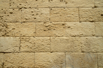 Old stone wall with limestone erosion closeup in Lecce, Italy