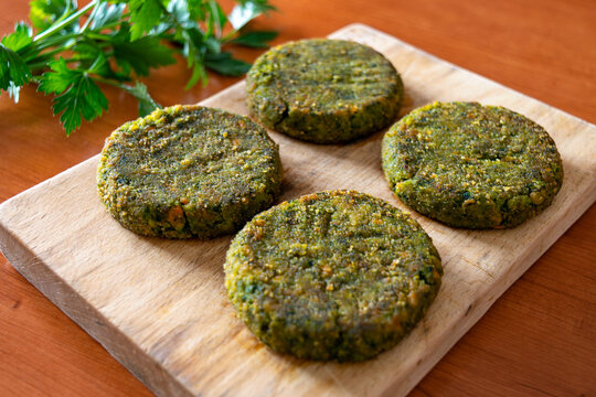 Close-up view of four vegan burger patties on a wooden board, natural plant-based food concept