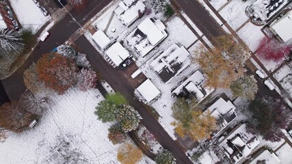Drone shot and aerial view of Columbus, Ohio neighborhood homes, buildings, roads, buildings, and businesses during late fall after winter snowfall snow falling and colorful autumn trees and leaves up - Powered by Adobe