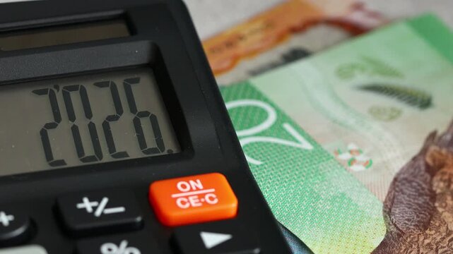  New Zealand. Finances 2026. Business and economic concept. Symbol of New Zealand dollars. Counting money. The year 2026 displayed on a calculator. Financial background. close up