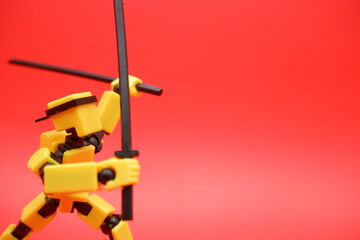 Toy Action Figure Posing with Dual Swords on Red Background