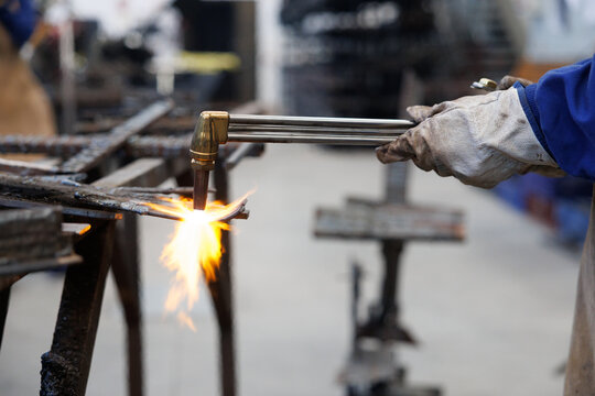 Artisan worker cutting metal with oxy-acetylene torch