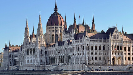 Fototapeta premium Still photo of the Hungarian Parliament Building viewed from the Danube River, showcasing its Gothic Revival architecture and grand riverside presence. 
