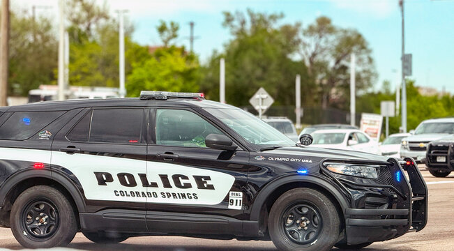 Colorado Springs, Colorado, USA - 21 May 2025: Police patrol car of the Colorado Springs Police Department with red and blue flashing lights blocking the road at a road traffic accident