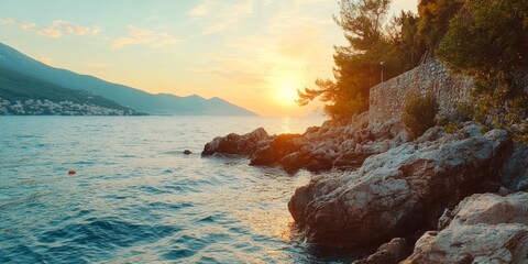 A tranquil seaside scene at dusk with a stunning sunset casting warm hues on the calm ocean.