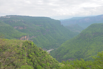 Breathtaking horizontal view of the lush Huentitan Canyon from the Viewpoint, surrounded by greenery and scenic cliffs
