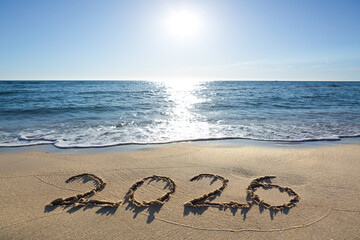 New Year 2026, lettering on the sunny beach sand.