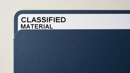 Document labeled classified material inside blue folder
