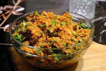 An image of kısır made with homemade bulgur in a glass bowl. Lettuce, green onions, and parsley...