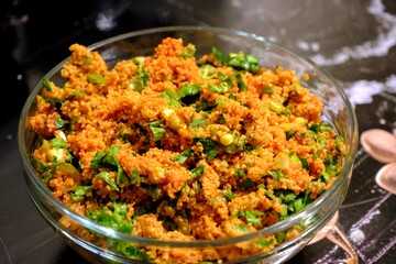 An image of kısır made with homemade bulgur in a glass bowl. Lettuce, green onions, and parsley are added to the kısır. Traditional Turkish food. Vegan diet. Snack plate.