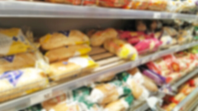 Defocused shelves with fresh bread and buns. Sale. Grocery shopping. Blur image of supermarket background. CPG product. Store. Retail industry. Rack. Food crisis concept. Increased demand. Consumer