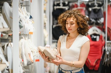 Young woman choosing sneakers in a fashion store