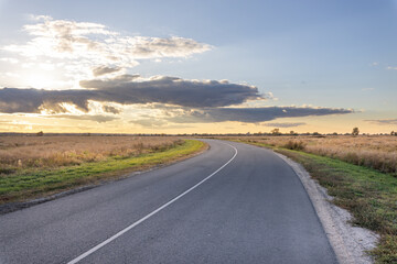 Long road with a few clouds in the sky