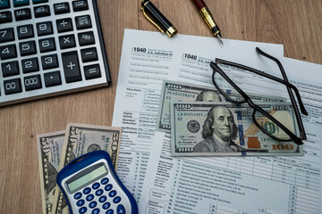Financial review with 1040 form, US dollar notes, glasses and calculator — 2025 report