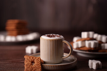 warm vintage coffee scene with latte art in textured mug, surrounded by gingerbread cookies and marshmallows on wooden table setting for cozy atmosphere, inviting, peaceful, decor, chocolate