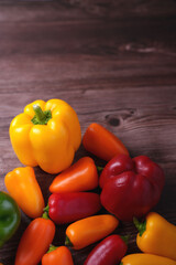 vibrant assortment of colorful bell peppers on rustic wooden surface capturing freshness and diversity in a harmonious composition of shapes and hues, nature, photography, earthy, warm, mood
