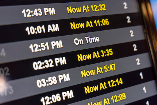 An airline schedule digital display showing delayed and cancelled flights