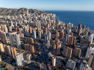 Aerial view of Benidorm, Spain, showcasing high-rise buildings and the Mediterranean Sea in the background.