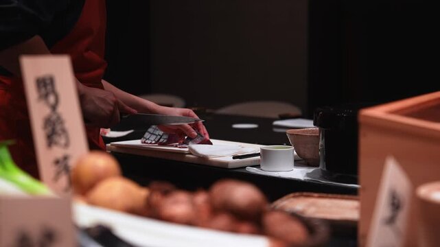 Close up shows hands slicing red fish on a white board in Tokyo. Warm low key lighting, shallow depth of field, strong bokeh, neat sashimi rows, rhythmic motion.