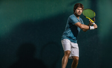 Tennis player. Energetic athlete in motion playing tennis match on court showing dynamic movement power and determination