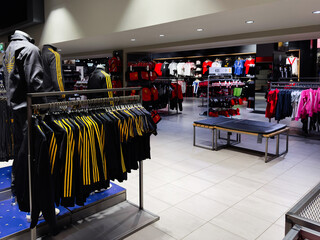Naklejka premium Modern Manchester store interior with sportswear on racks and a bench for shoppers