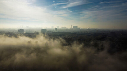 Fototapeta premium Foggy industrial cityscape at sunrise 