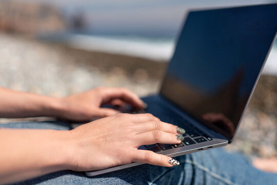 Laptop hands typing beach remote work digital nomad travel