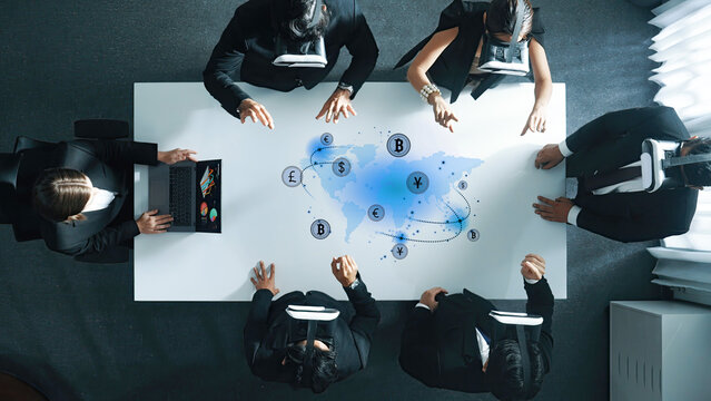 Business professionals engage in a corporate meeting using virtual reality technology to explore and analyze financial data, enhancing innovation and collaboration. Trope