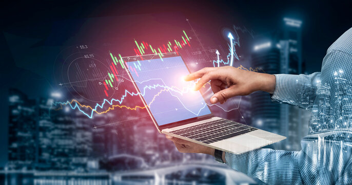 A person uses a laptop to assess financial data with vibrant graphs and city skyline. The image highlights technology, analysis, and urban business dynamics. Scalp - Powered by Adobe