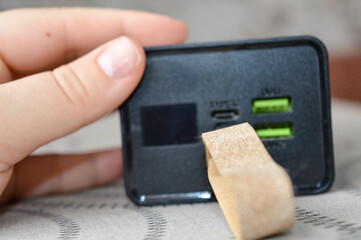 portable power bank with digital display and USB ports held in hand, concept of mobile charging, modern technology, portable energy source, and electronic device for everyday use and travel.