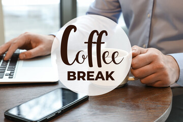 Coffee break time. Office worker with cup of hot drink using laptop at desk, closeup